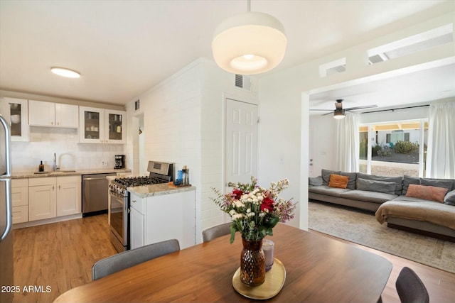 dining room featuring sink, light hardwood / wood-style flooring, and ceiling fan