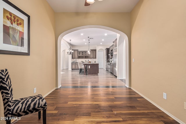 corridor featuring dark hardwood / wood-style flooring and a chandelier