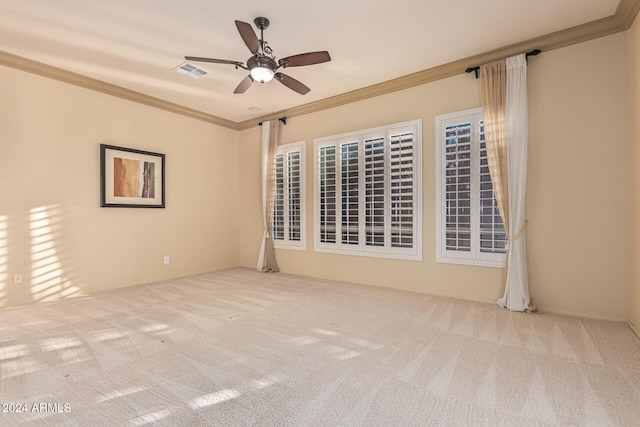 carpeted spare room with ceiling fan and crown molding