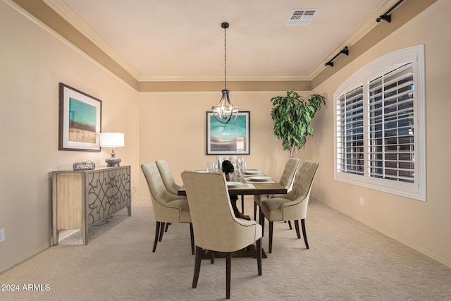 dining space with carpet flooring, ornamental molding, and a chandelier