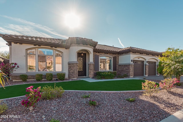 mediterranean / spanish home featuring a front lawn and a garage