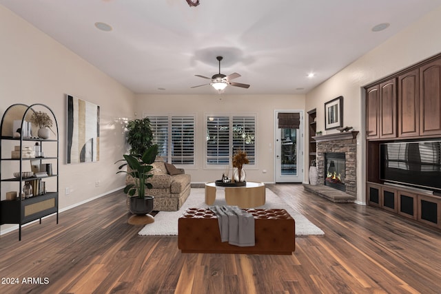 living room featuring dark hardwood / wood-style floors, ceiling fan, and a fireplace