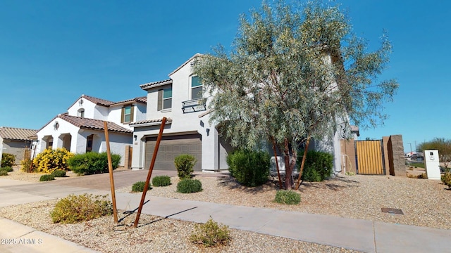 view of front of home with stucco siding, fence, a garage, driveway, and a tiled roof