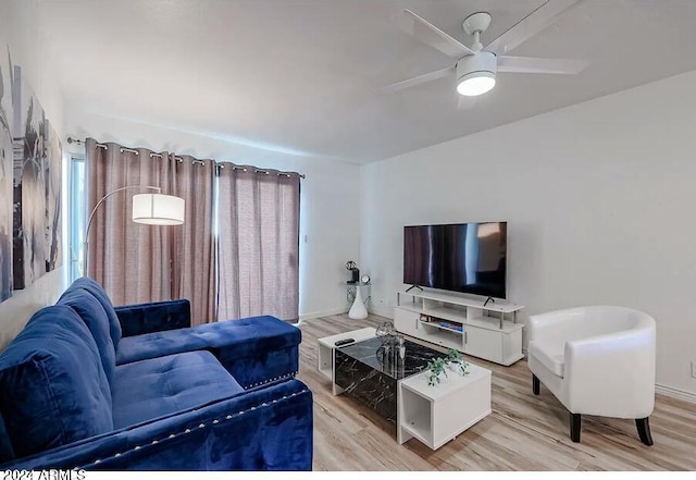 living room with light wood-style floors, baseboards, and a ceiling fan