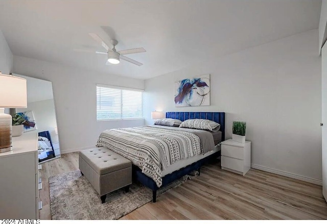 bedroom featuring a ceiling fan, light wood-style floors, and baseboards
