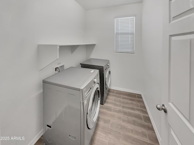 21081 W Almeria Rd, Buckeye, AZ 85396 - washroom featuring wood tiled floor, washer and dryer, baseboards, and laundry area