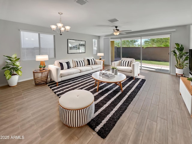 21081 W Almeria Rd, Buckeye, AZ 85396 - living room featuring light wood finished floors, baseboards, visible vents, and ceiling fan with notable chandelier