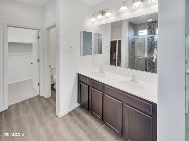 21081 W Almeria Rd, Buckeye, AZ 85396 - bathroom featuring toilet, a sink, double vanity, and a stall shower