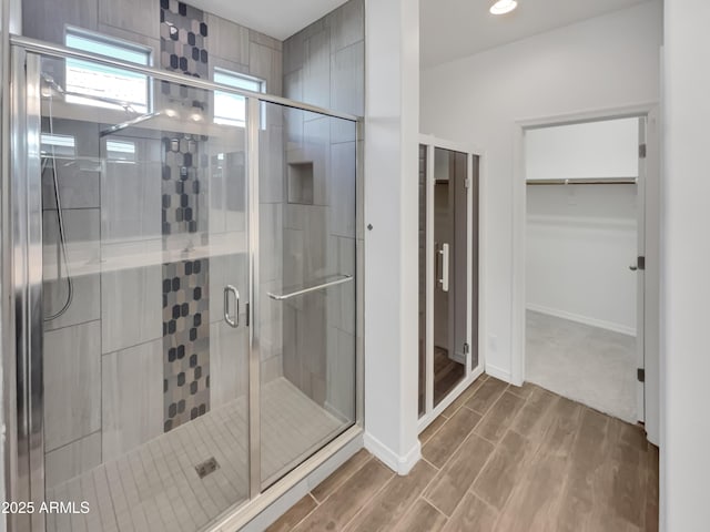 21081 W Almeria Rd, Buckeye, AZ 85396 - full bathroom with a stall shower, baseboards, recessed lighting, wood finished floors, and a walk in closet