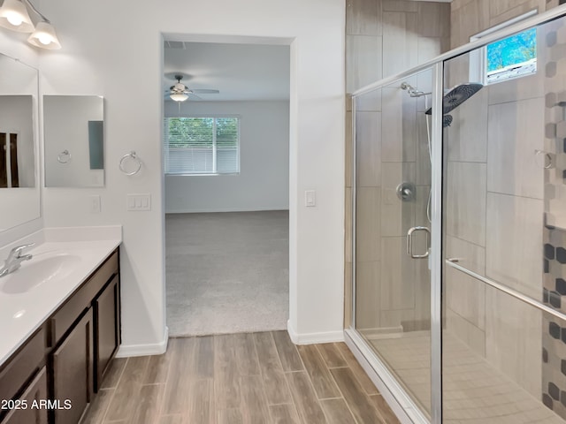 21081 W Almeria Rd, Buckeye, AZ 85396 - bathroom with wood finished floors, vanity, a shower stall, and ceiling fan