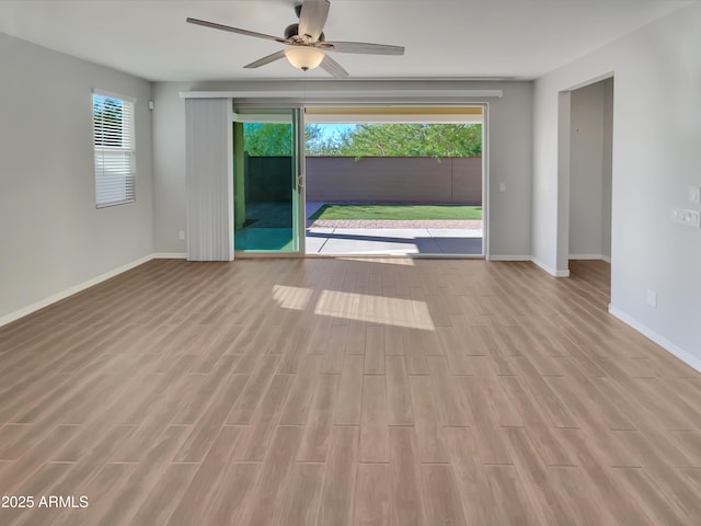 21081 W Almeria Rd, Buckeye, AZ 85396 - spare room featuring wood finished floors, baseboards, and ceiling fan