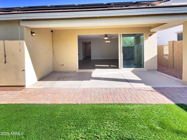 21081 W Almeria Rd, Buckeye, AZ 85396 - doorway to property with stucco siding, solar panels, a ceiling fan, and a patio