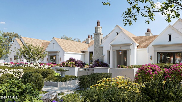 view of front of property featuring a fenced front yard, a chimney, and stucco siding