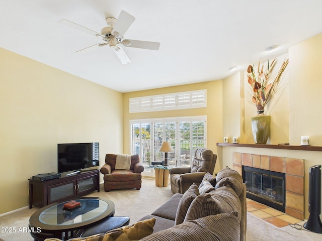 living area featuring baseboards, a fireplace, ceiling fan, and carpet flooring