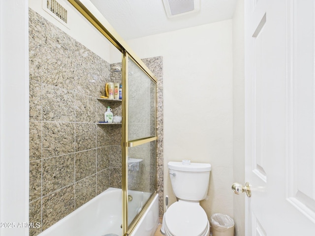 bathroom featuring combined bath / shower with glass door, visible vents, and toilet