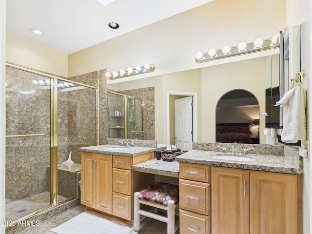 bathroom featuring connected bathroom, two vanities, a sink, and a shower stall