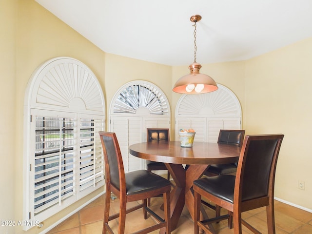 dining space with baseboards and tile patterned flooring