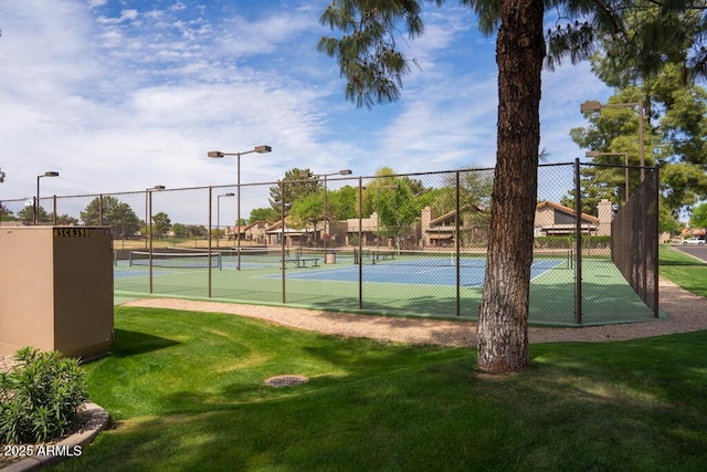 view of sport court featuring a yard and fence