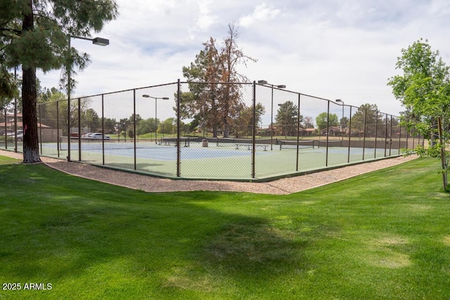 view of sport court with fence and a yard