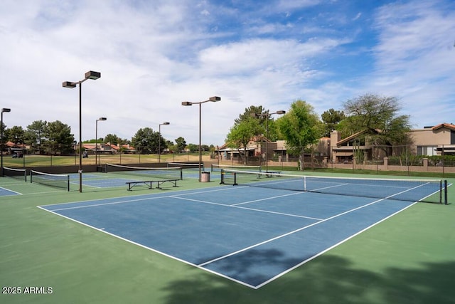 view of tennis court with community basketball court and fence
