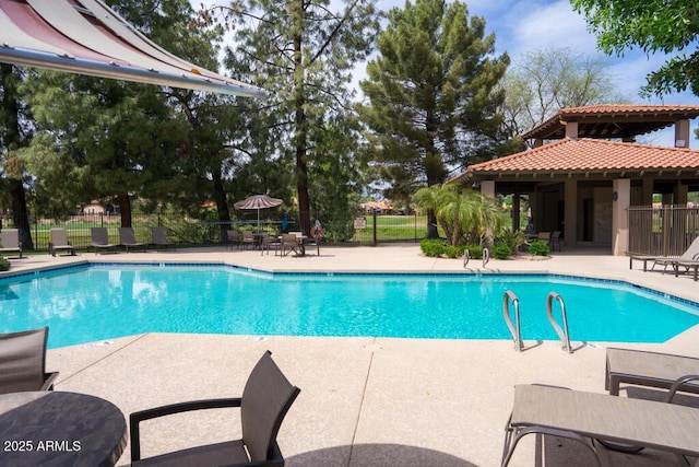community pool with fence and a patio area
