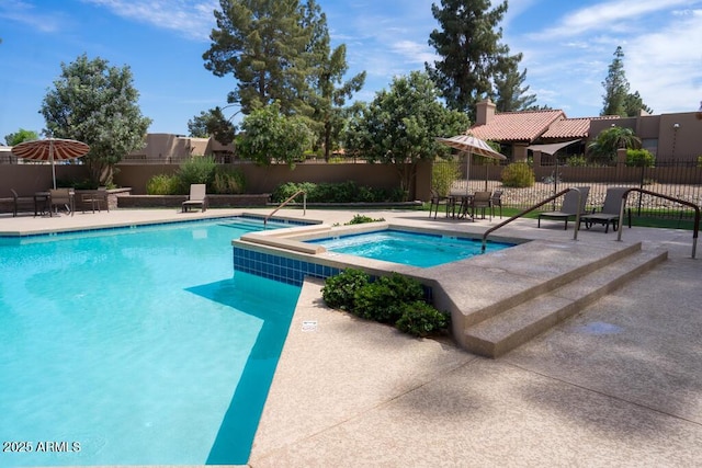 community pool featuring a hot tub, fence, and a patio