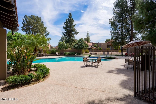 community pool with fence and a patio