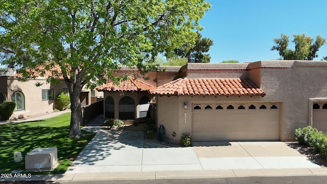 view of front of home featuring driveway, a tiled roof, a garage, a front lawn, and stucco siding
