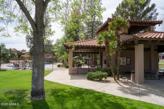 view of community with a patio, fence, a lawn, and a pool
