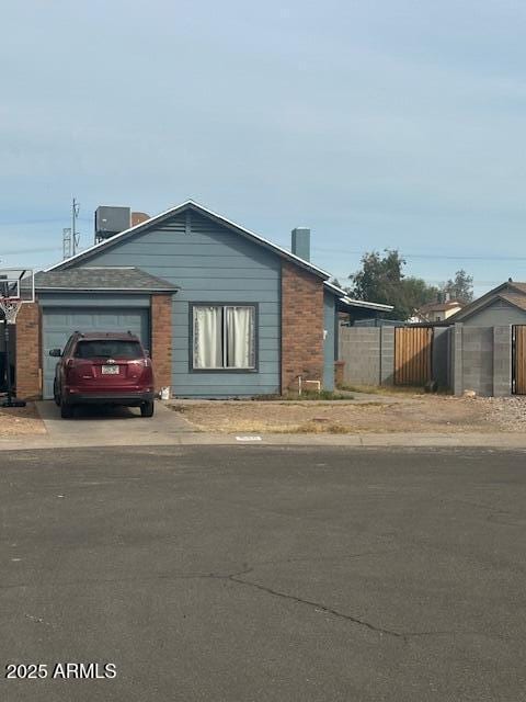 view of front of home with a garage, cooling unit, driveway, and fence