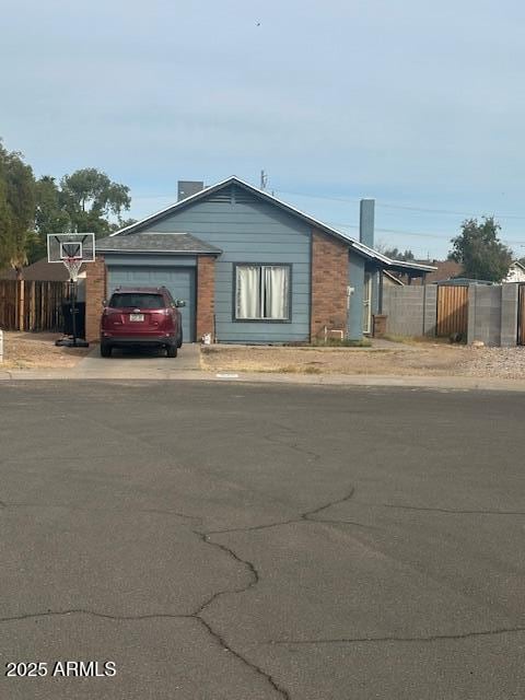 view of front facade with concrete driveway, fence, and a garage