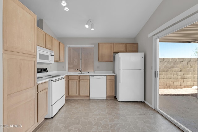 kitchen with sink, light brown cabinets, and white appliances