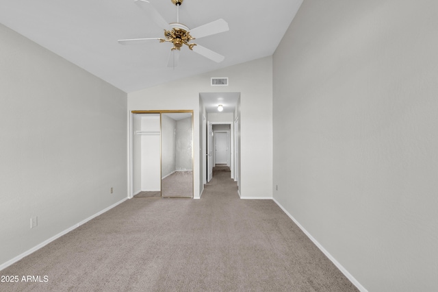 unfurnished bedroom with ceiling fan, light colored carpet, a closet, and lofted ceiling