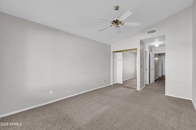 unfurnished bedroom featuring ceiling fan, a closet, carpet floors, and lofted ceiling