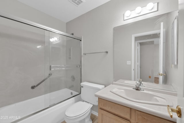 full bathroom featuring toilet, enclosed tub / shower combo, and vanity