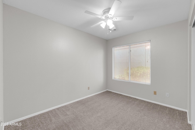 carpeted spare room featuring ceiling fan