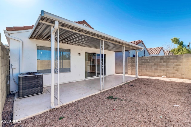 back of property with central AC and a patio