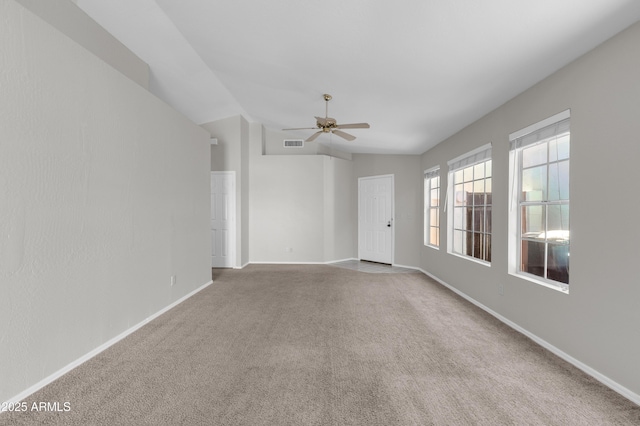 carpeted empty room featuring ceiling fan and vaulted ceiling