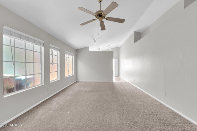 carpeted empty room featuring vaulted ceiling and ceiling fan