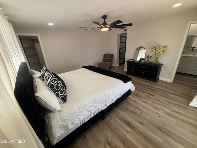 bedroom with recessed lighting, ceiling fan, ensuite bath, wood finished floors, and baseboards