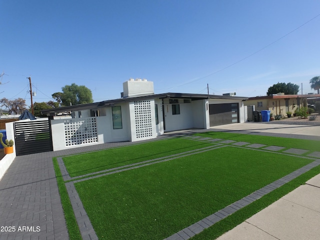 view of front of home featuring a front yard, concrete driveway, an attached carport, and stucco siding