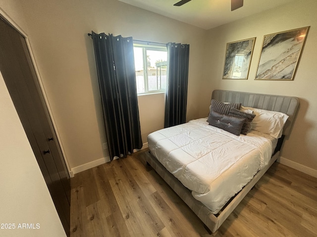 bedroom featuring baseboards, vaulted ceiling, and wood finished floors