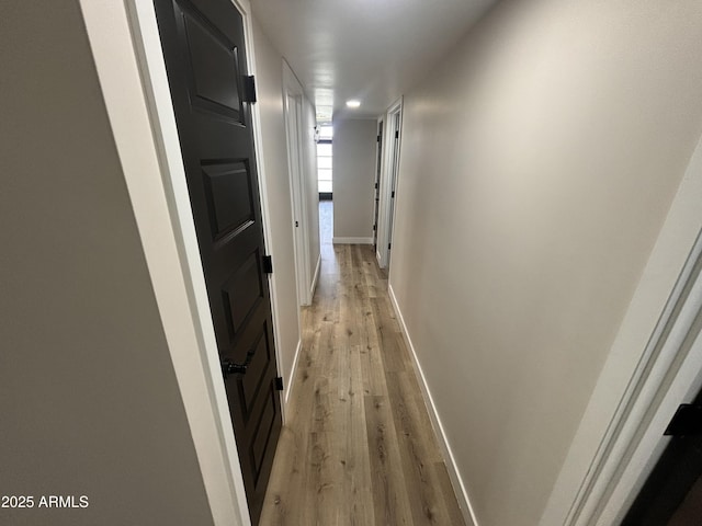 hall featuring light wood-style floors and baseboards