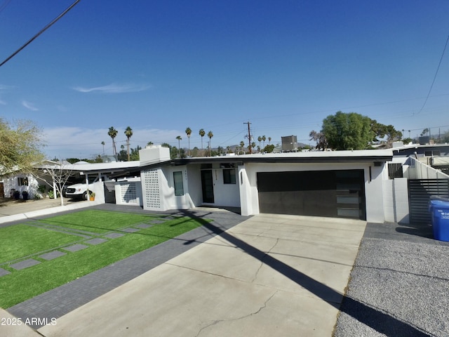 view of front of property with driveway, an attached garage, and stucco siding