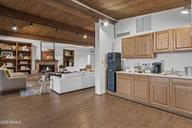 1522 W Myrtle Ave, Phoenix, AZ 85021 - kitchen with track lighting, a wooden ceiling with exposed beams, light countertops, dark wood-style flooring, and a lit fireplace