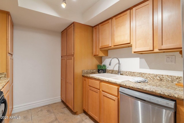 kitchen with light tile patterned flooring, light brown cabinetry, sink, light stone counters, and dishwasher