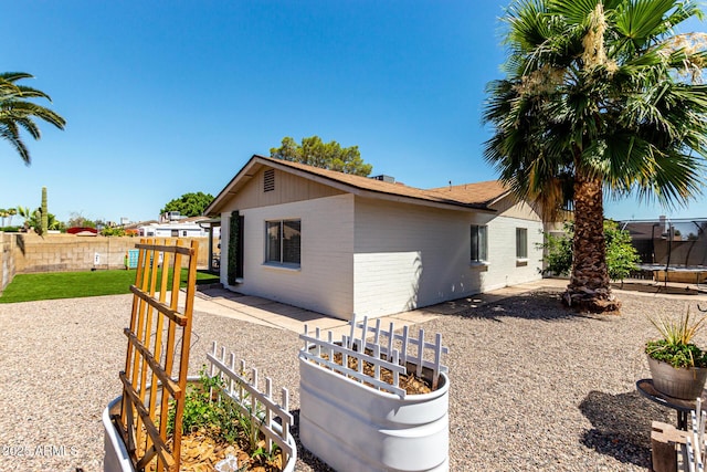 5302 W Poinsettia Dr, Glendale, AZ 85304 - view of property exterior featuring a trampoline, a fenced backyard, and brick siding
