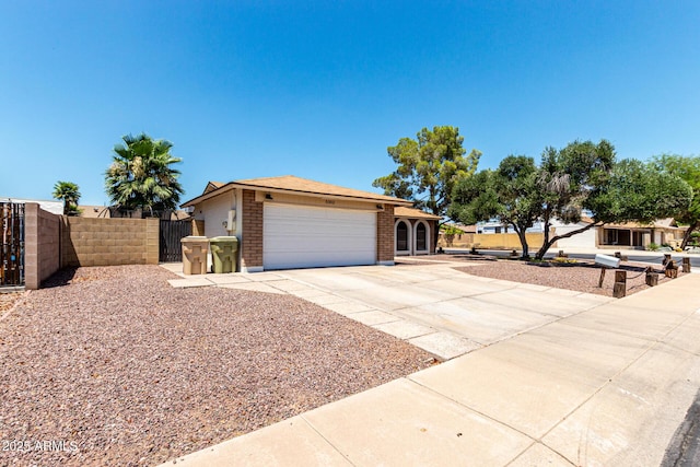 5302 W Poinsettia Dr, Glendale, AZ 85304 - view of front of house featuring concrete driveway, an attached garage, a gate, and brick siding