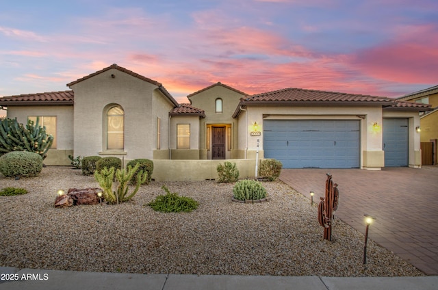 3753 E Ellis St, Mesa, AZ 85205 - mediterranean / spanish house featuring stucco siding, decorative driveway, a tile roof, and a garage