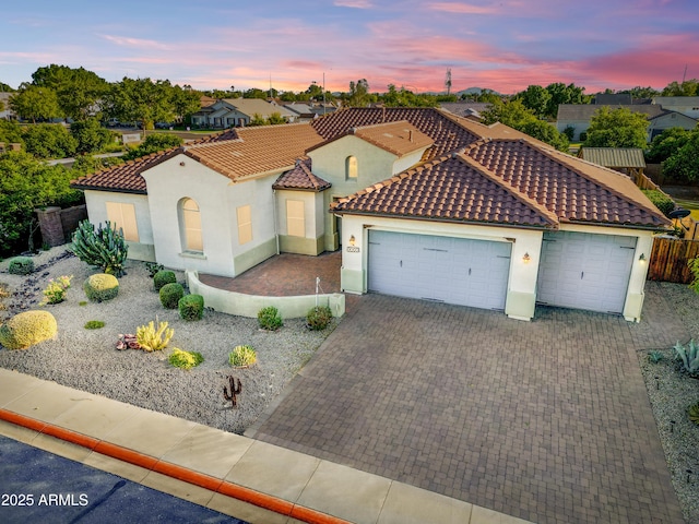 3753 E Ellis St, Mesa, AZ 85205 - mediterranean / spanish-style home featuring decorative driveway, stucco siding, a tiled roof, an attached garage, and a residential view